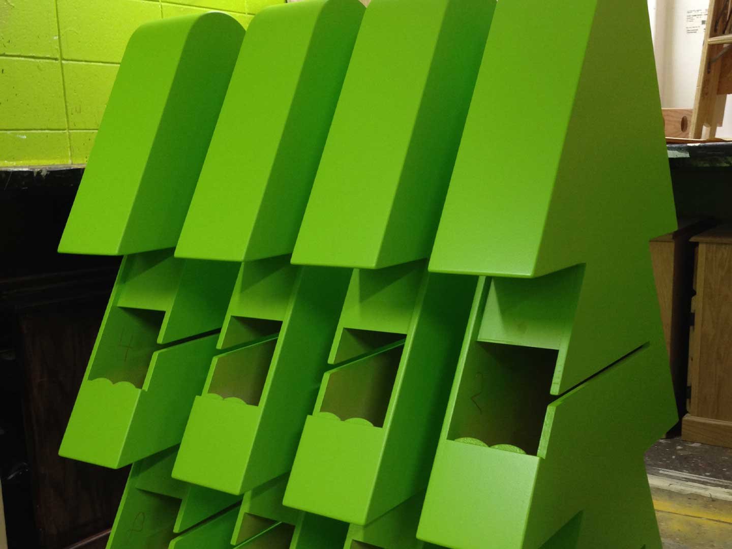 Custom display trade show booths fabrication process of painting green displays.