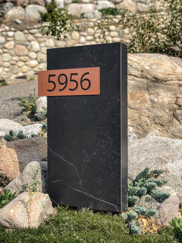 House numbers sign made of quartz with copper coloured numbers.