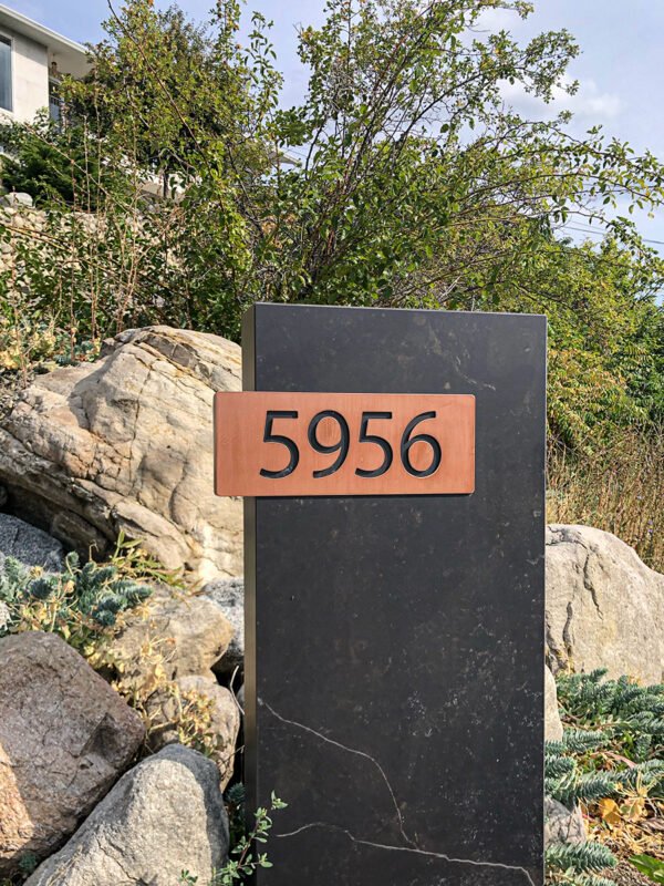 House numbers sign made of quartz with copper coloured numbers.
