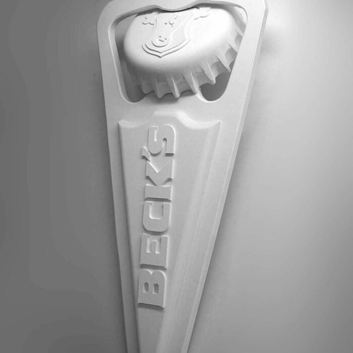 DSCN0369 - The Bees Knees Design White plastic handheld tool with a serrated, comb-like edge and raised letters along the handle; branding visible on the tool.