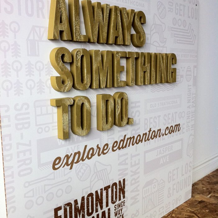 IMG_7423 - The Bees Knees Design Gold 3D letters spell 'ALWAYS SOMETHING TO DO' on a white wall with a grey patterned background. prop displays