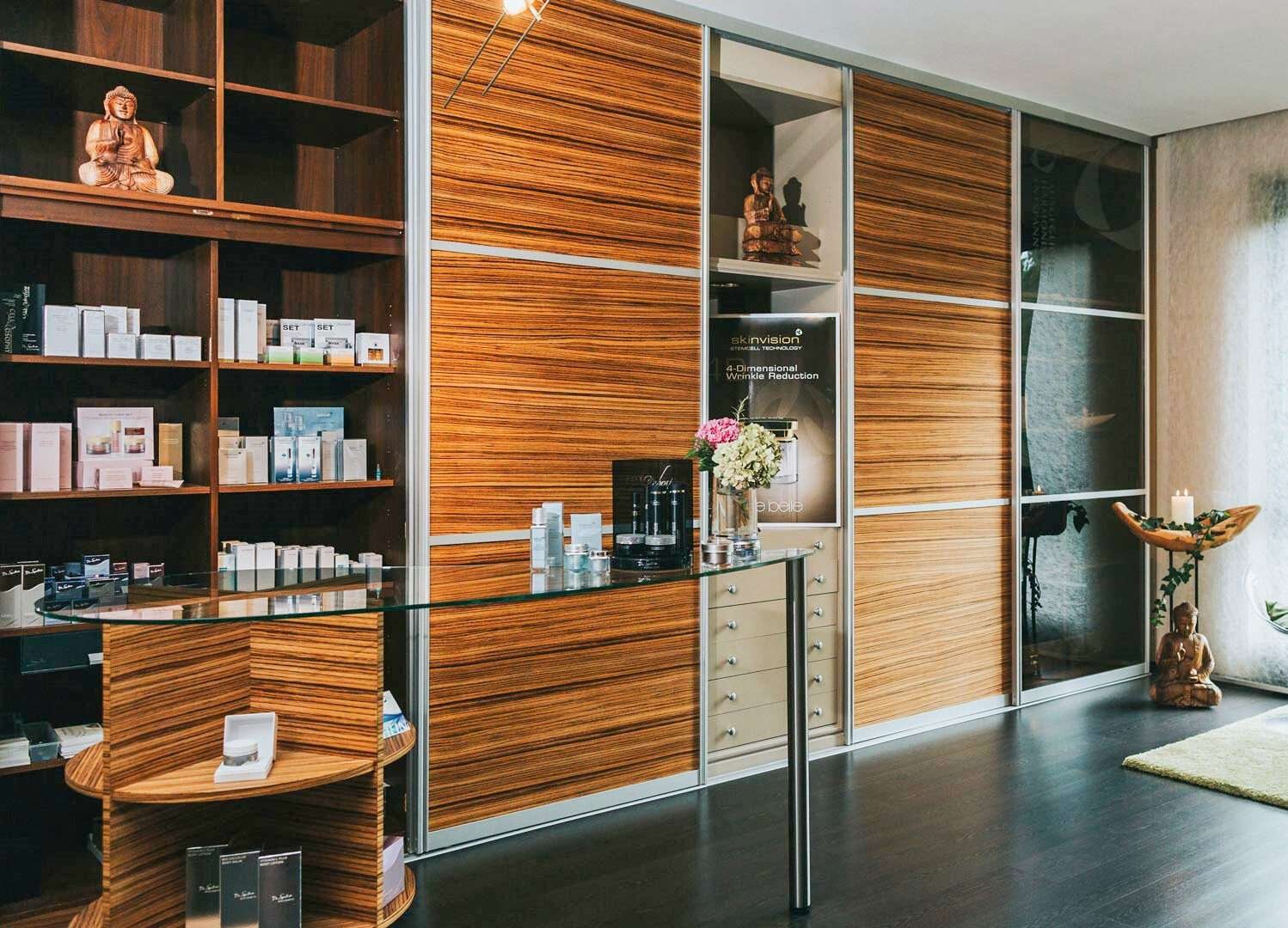 LOBBY Custom displays wall with wooden and glass sliding doors with spa products displayed.
